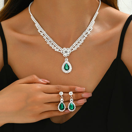 Luxury silver crystal necklace and earring set with emerald green teardrop pendants for women.